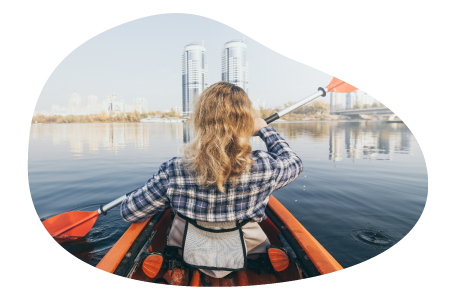 A member of a marina paddles a kayak on a river. A member of a marina paddles a kayak on a river.