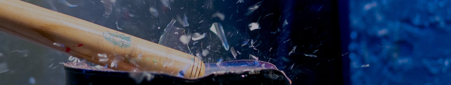 A bat shatters glass in a rage room. A bat shatters glass in a rage room.