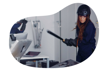 A rage room customer gets ready to strike with a bat. A rage room customer gets ready to strike with a bat.