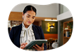 A resort owner works on a tablet in the lobby.