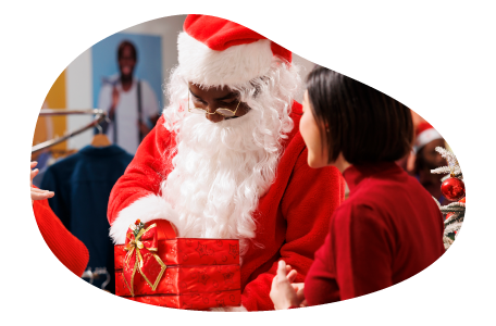 A mall Santa gives a gift to a child.