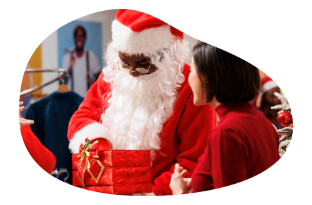 A mall Santa gives a gift to a child. A mall Santa gives a gift to a child.