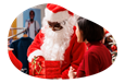 A mall Santa gives a gift to a child.