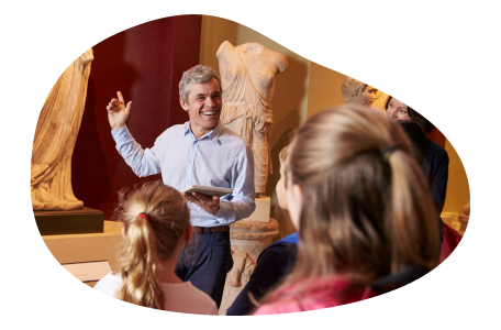 A tour guide shows a group a statue display at a museum.