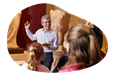 A tour guide shows a group a statue display at a museum.