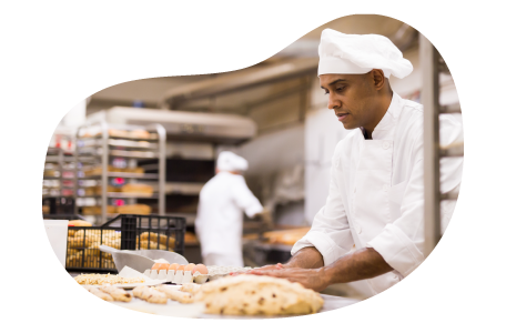 Baker preparing dough in a kitchen.