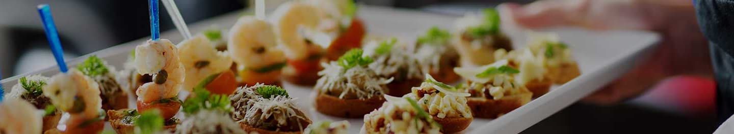 Hand holding out food on a platter.