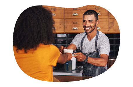 Barista handing a cup of coffee to a customer.