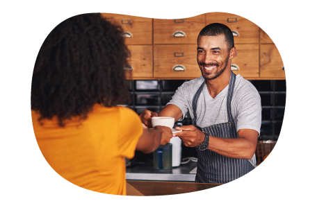 Barista handing a cup of coffee to a customer. Barista handing a cup of coffee to a customer.