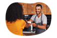 Barista handing a cup of coffee to a customer.