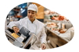 Deli employee slicing meat.