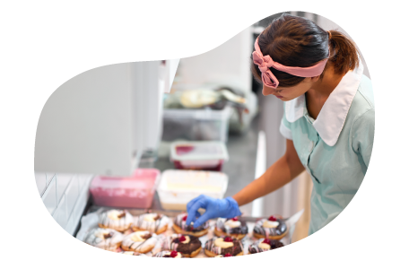 A donut shop owner assembling a new batch of donuts A donut shop owner assembling a new batch of donuts
