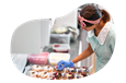 A donut shop owner assembling a new batch of donuts