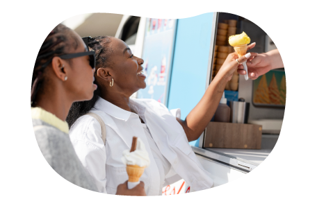 A customer gets an ice cream cone from an ice cream truck.