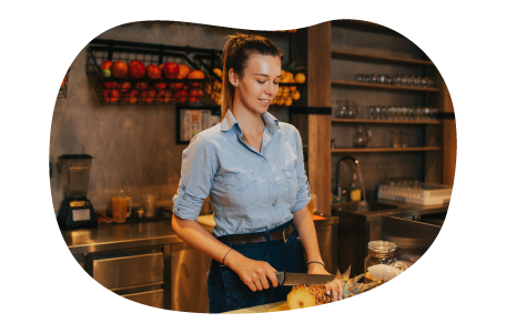 Juice bar employee slicing fruit.