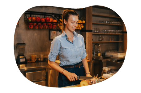 Juice bar employee slicing fruit. Juice bar employee slicing fruit.