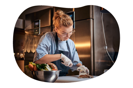 A personal chef slices mushrooms for a dish.