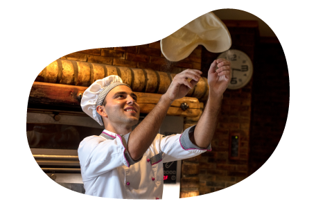 A chef tosses pizza dough in the air. A chef tosses pizza dough in the air.