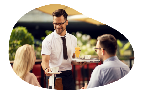 Waiter serving customers a meal in a restaurant.