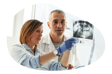 Dental lab technicians reviewing patient x-rays. Dental lab technicians reviewing patient x-rays.