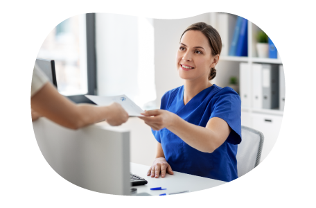 Patient handing paperwork to staff in a medical office.
