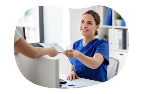 Patient handing paperwork to staff in a medical office.