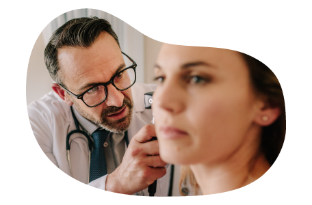 Audiologist examining a patient's ear.