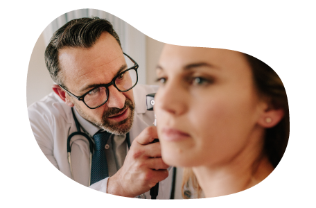 Audiologist examining a patient's ear. Audiologist examining a patient's ear.