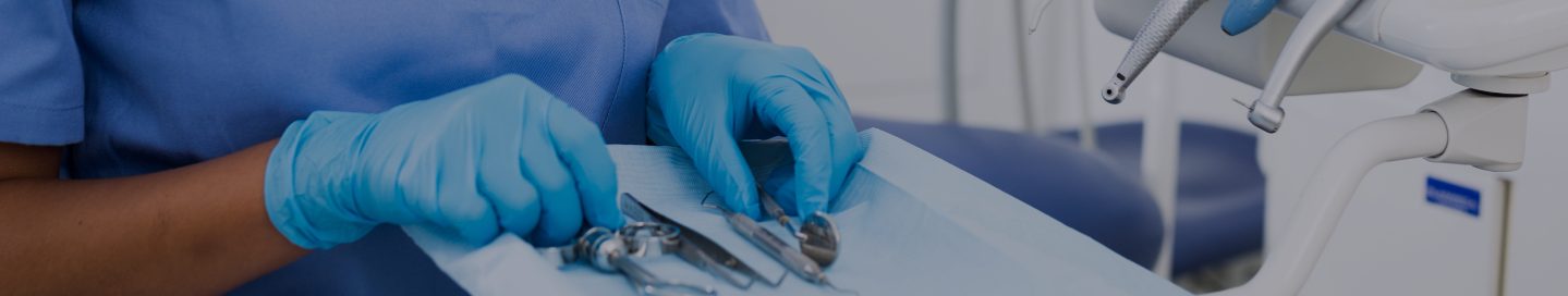A dental hygienist with a tray of dentistry tools.
