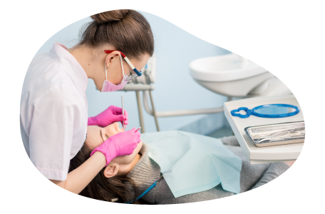 A dental hygienist cleans a patient's teeth.