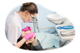 A dental hygienist cleans a patient's teeth.