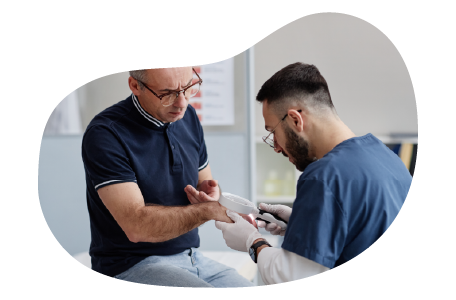 A dermatologist examines the skin on a patient's hand.