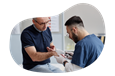 A dermatologist examines the skin on a patient's hand.