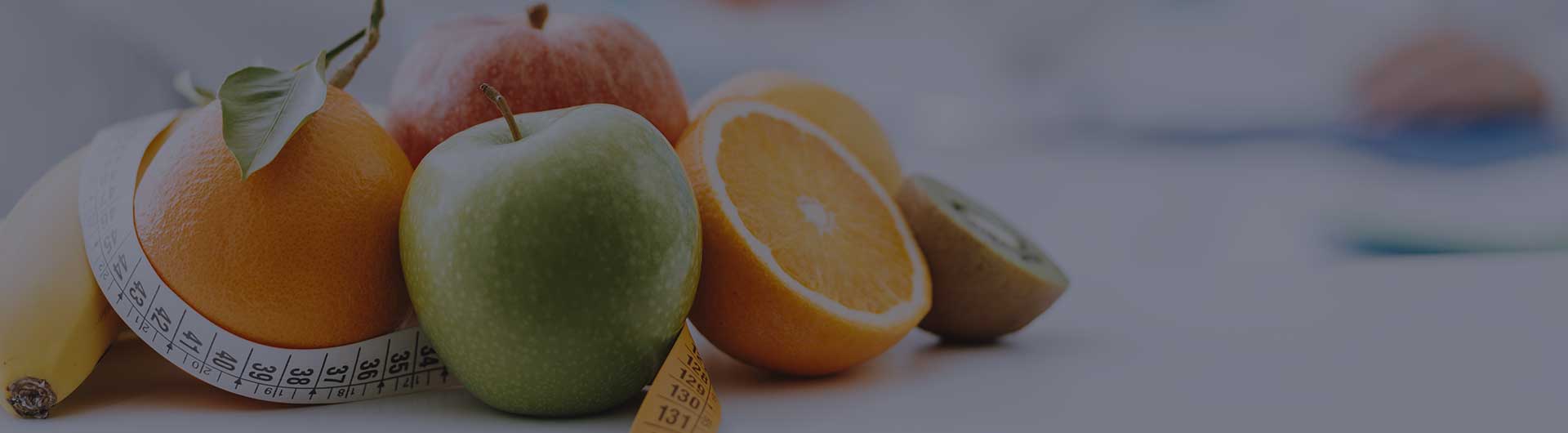Professional dietitian meets a patient in the office with healthy fruits and a tape measure in the foreground.