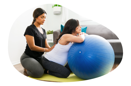 A doula works with a client using an exercise ball.