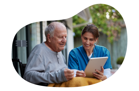 A hospice care nurse helps a patient with a tablet. A hospice care nurse helps a patient with a tablet.