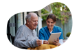 A hospice care nurse helps a patient with a tablet.