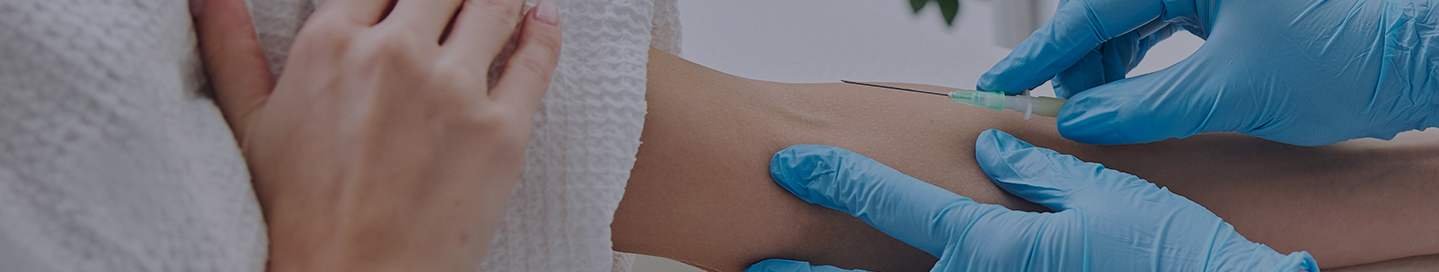 A nurse administers IV therapy to a patient in a clinic.