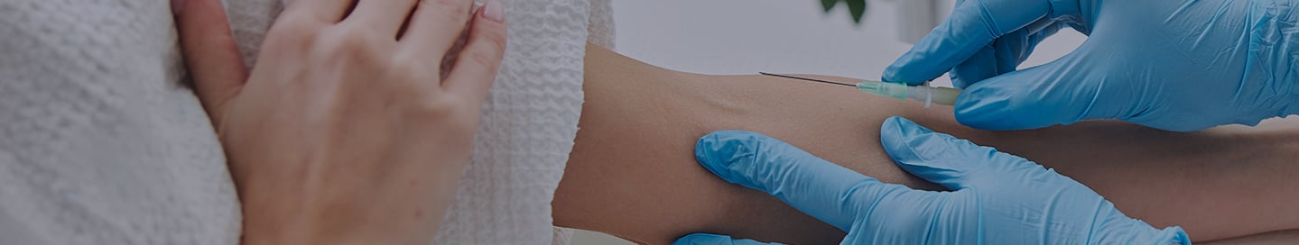 A nurse administers IV therapy to a patient in a clinic. A nurse administers IV therapy to a patient in a clinic.