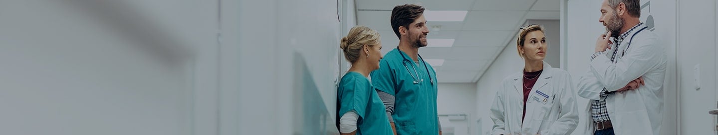 A group of medical professionals in a hospital hallway. A group of medical professionals in a hospital hallway.