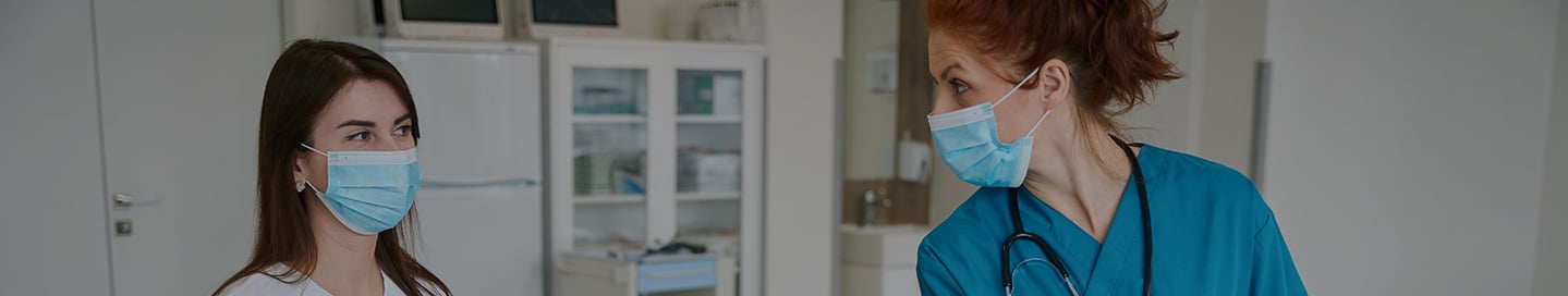 A nurse anesthetist (CRNA) discusses a patient's care with another nurse. A nurse anesthetist (CRNA) discusses a patient's care with another nurse.