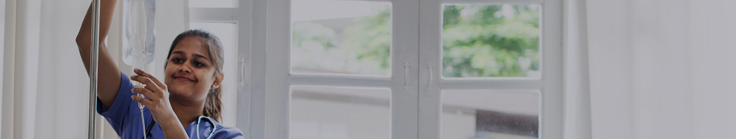 A nurse practitioner checks a patient's IV.