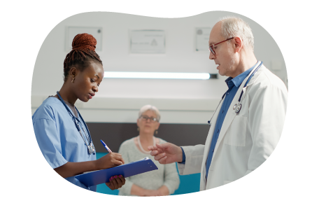 A nursing assistant takes notes from a doctor.