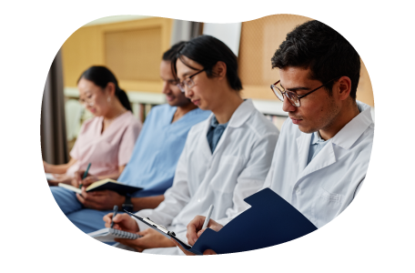 Nursing students taking notes in a classroom. Nursing students taking notes in a classroom.