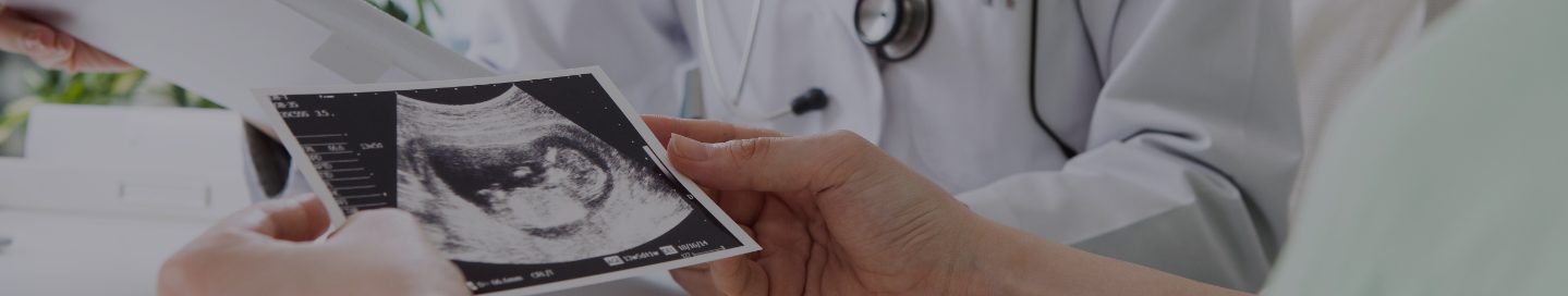 An OB/GYN looks over an ultrasound print with a patient.
