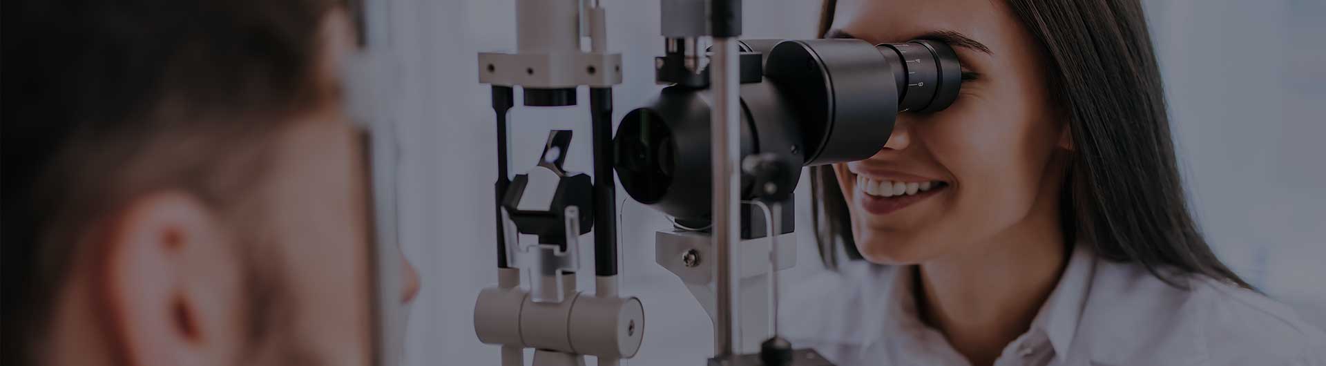 Female doctor ophthalmologist is checking the eye vision of a young man in modern clinic. Female doctor ophthalmologist is checking the eye vision of a young man in modern clinic.
