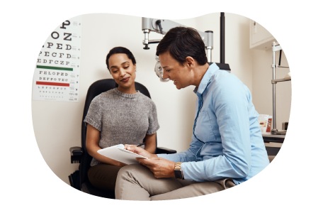 Optometrist reviewing paperwork with a patient.