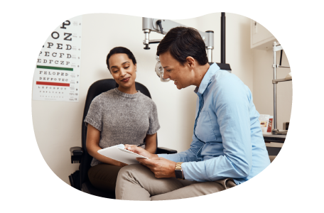 Optometrist reviewing paperwork with a patient.