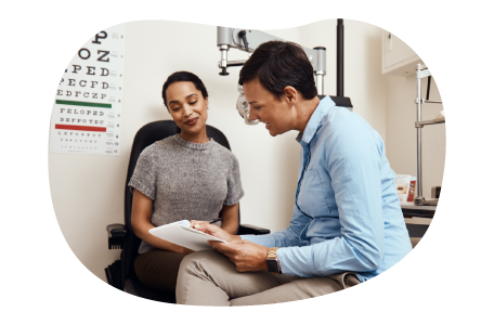 Optometrist reviewing paperwork with a patient. Optometrist reviewing paperwork with a patient.