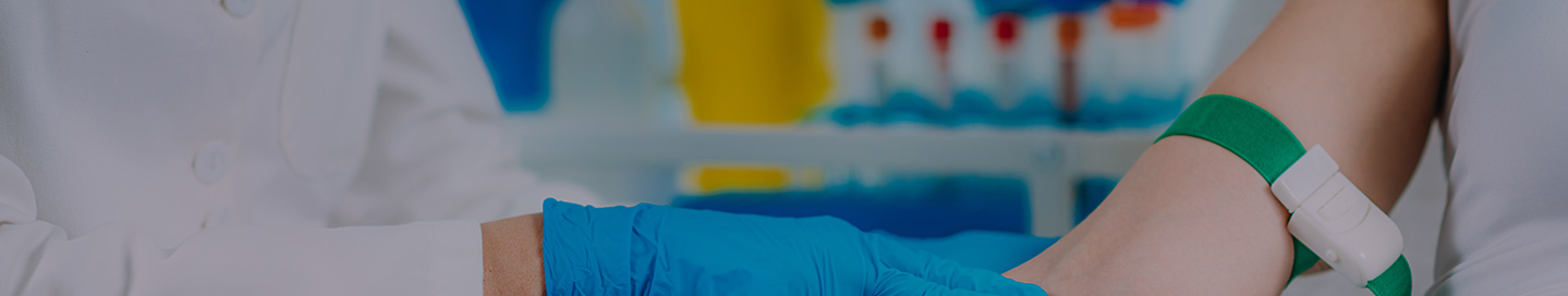 A phlebotomist feels for a vein on a patient.